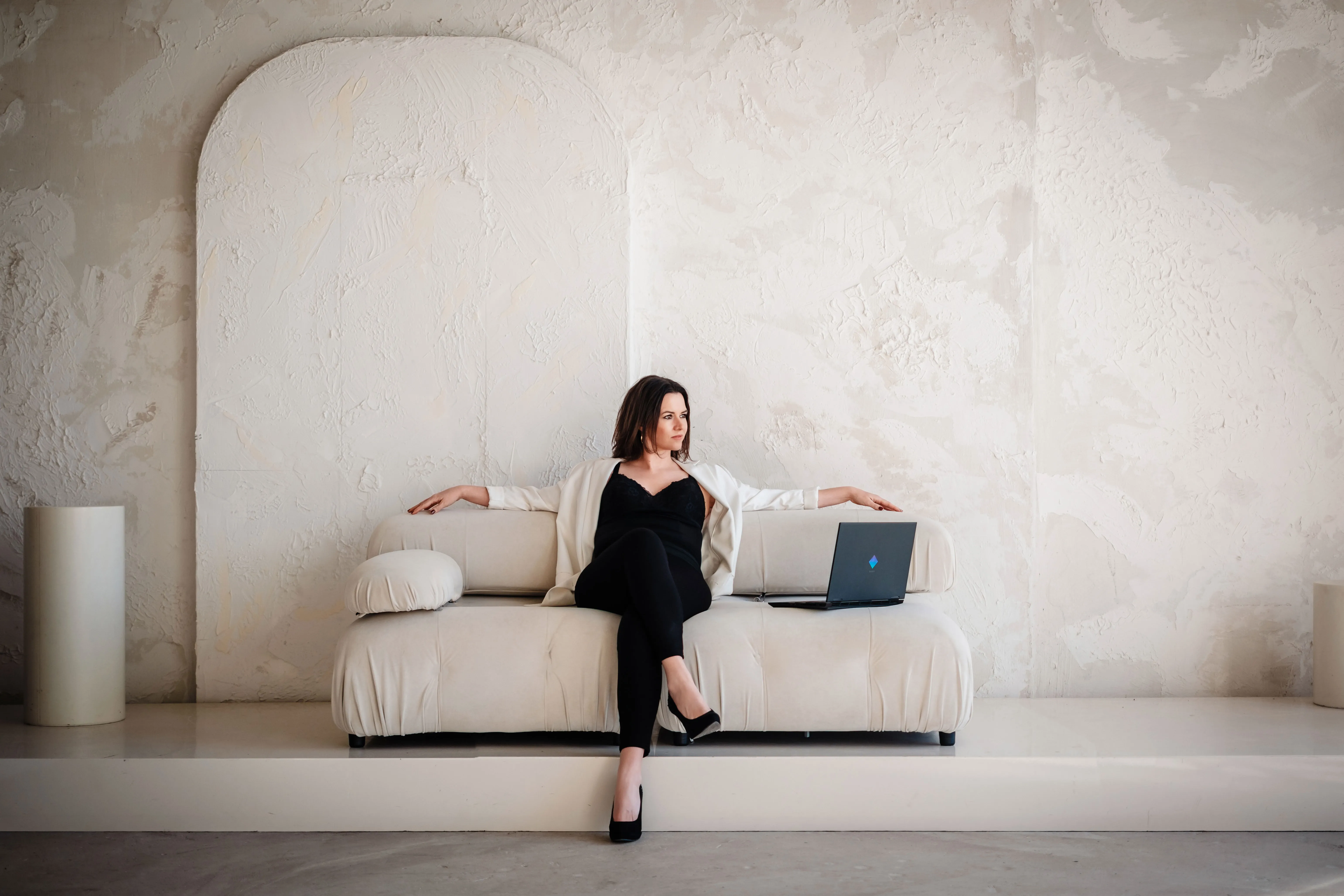 Sarah-Yasmin Hennessen arbeitet mit einem Laptop in einem hellen Studio.